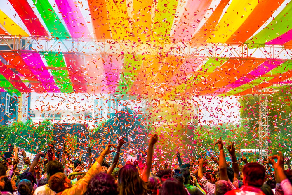 a crowd of people standing under a colorful canopy