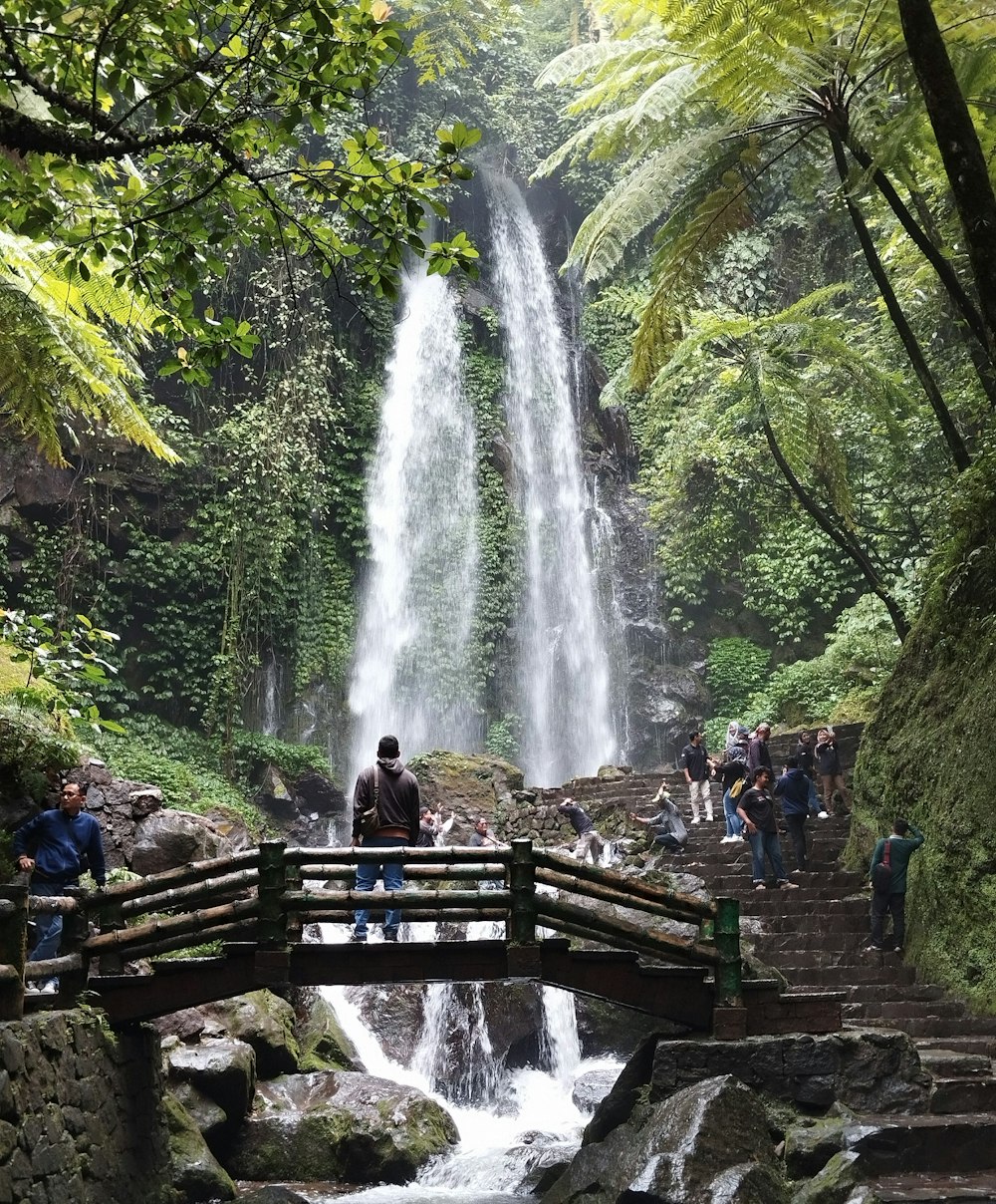 un gruppo di persone in piedi davanti a una cascata