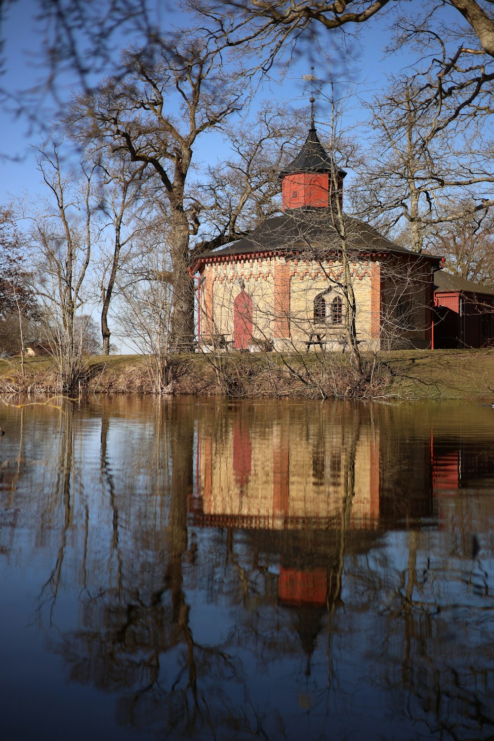 Un edificio situado en la cima de un lago junto a un bosque