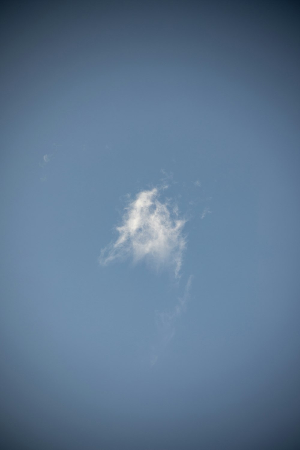 a plane flying in the sky with a cloud in the middle