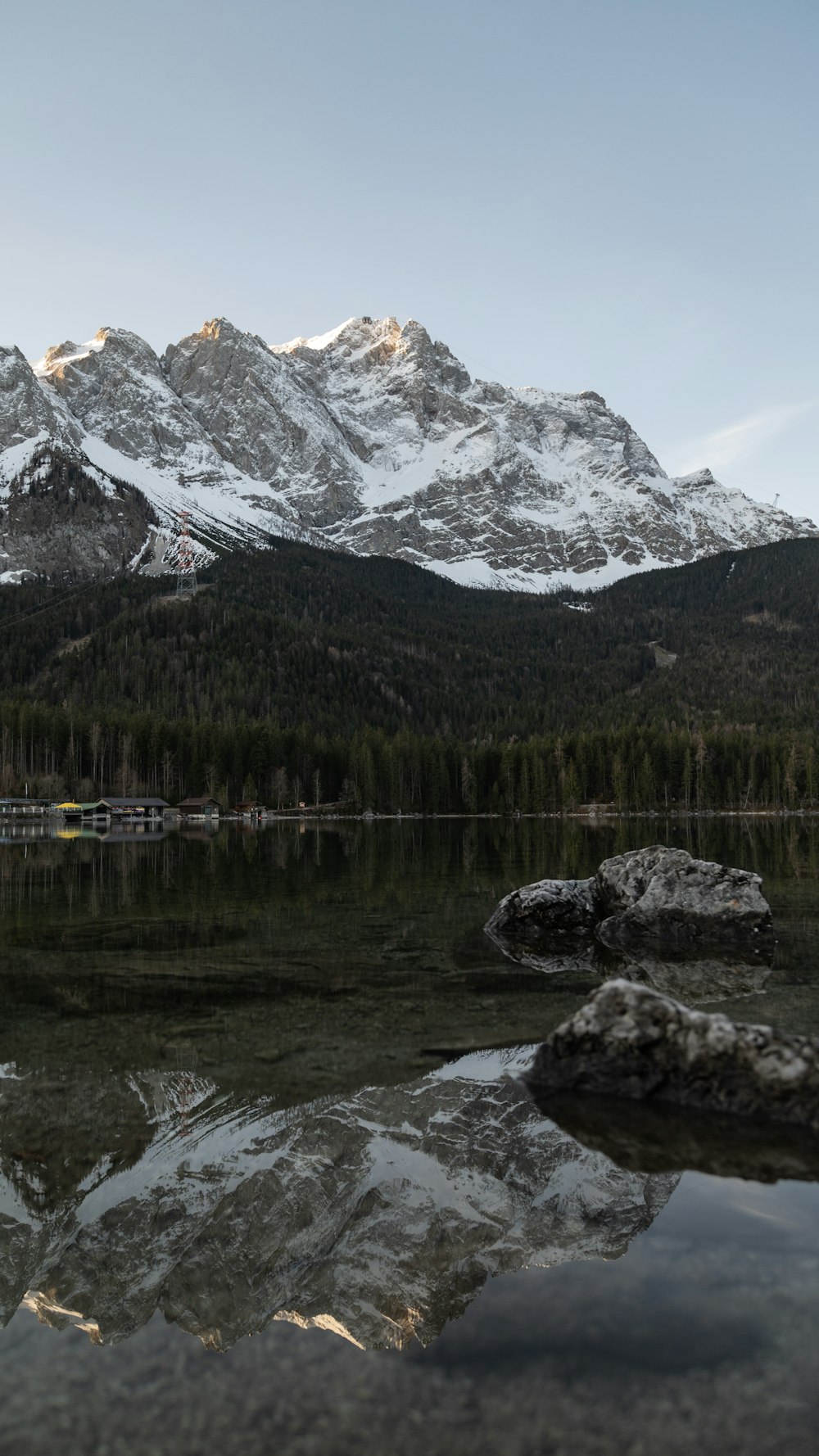 a mountain range is reflected in the still water of a lake