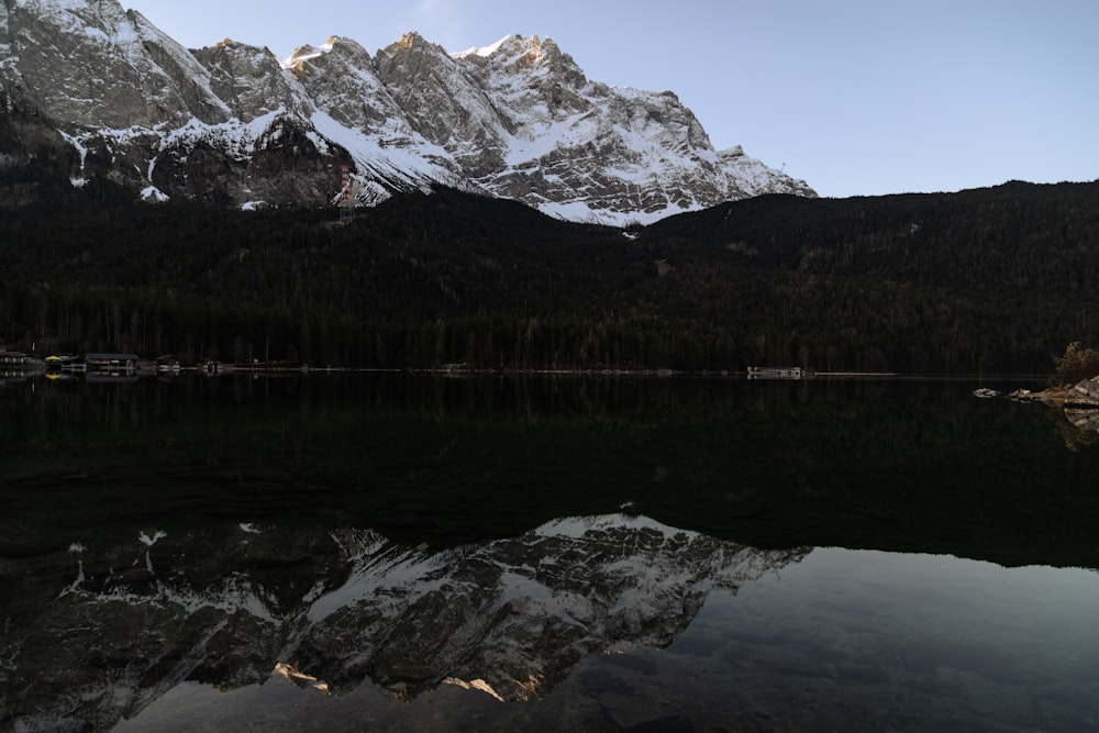 a mountain range is reflected in the still water of a lake