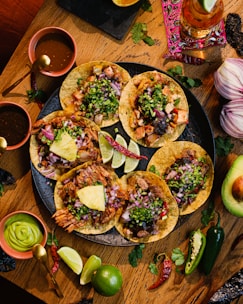 a wooden table topped with tacos and guacamole