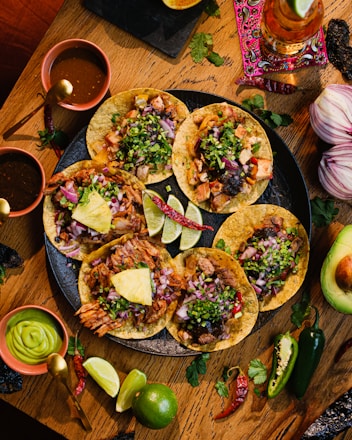 a wooden table topped with tacos and guacamole