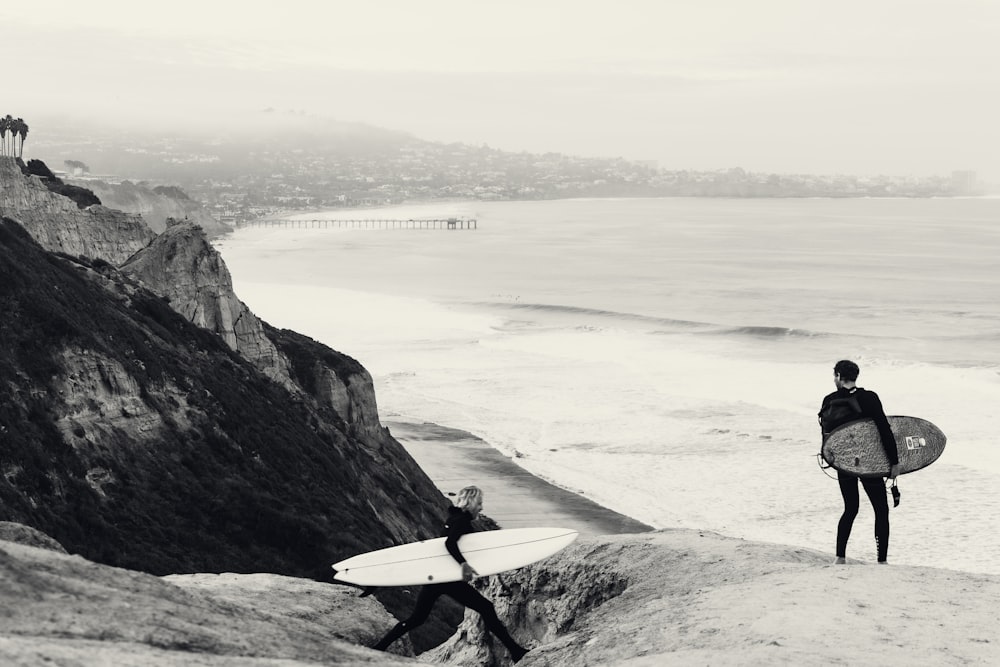 a couple of people standing on top of a beach