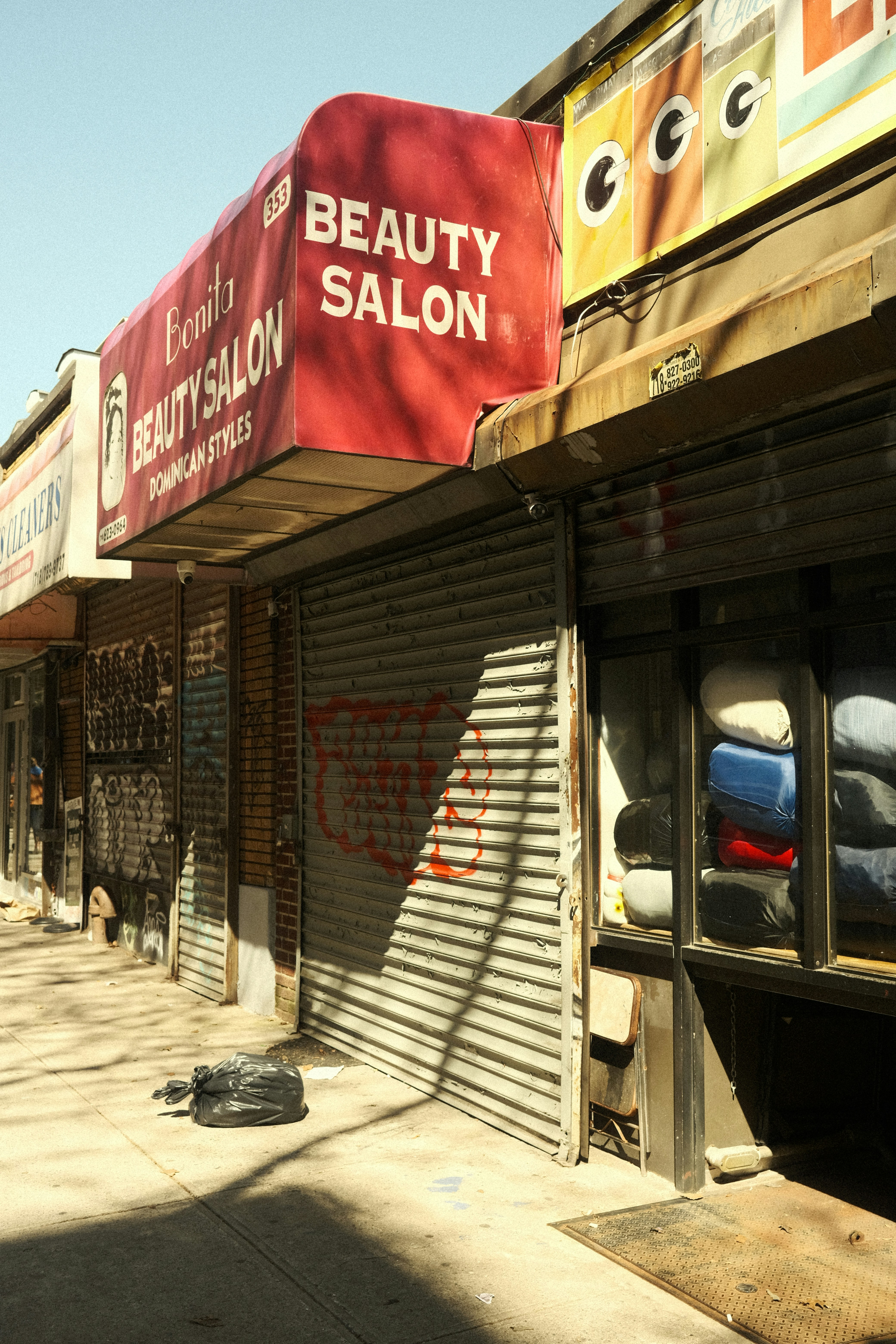 a row of shops with closed shutters on a city street