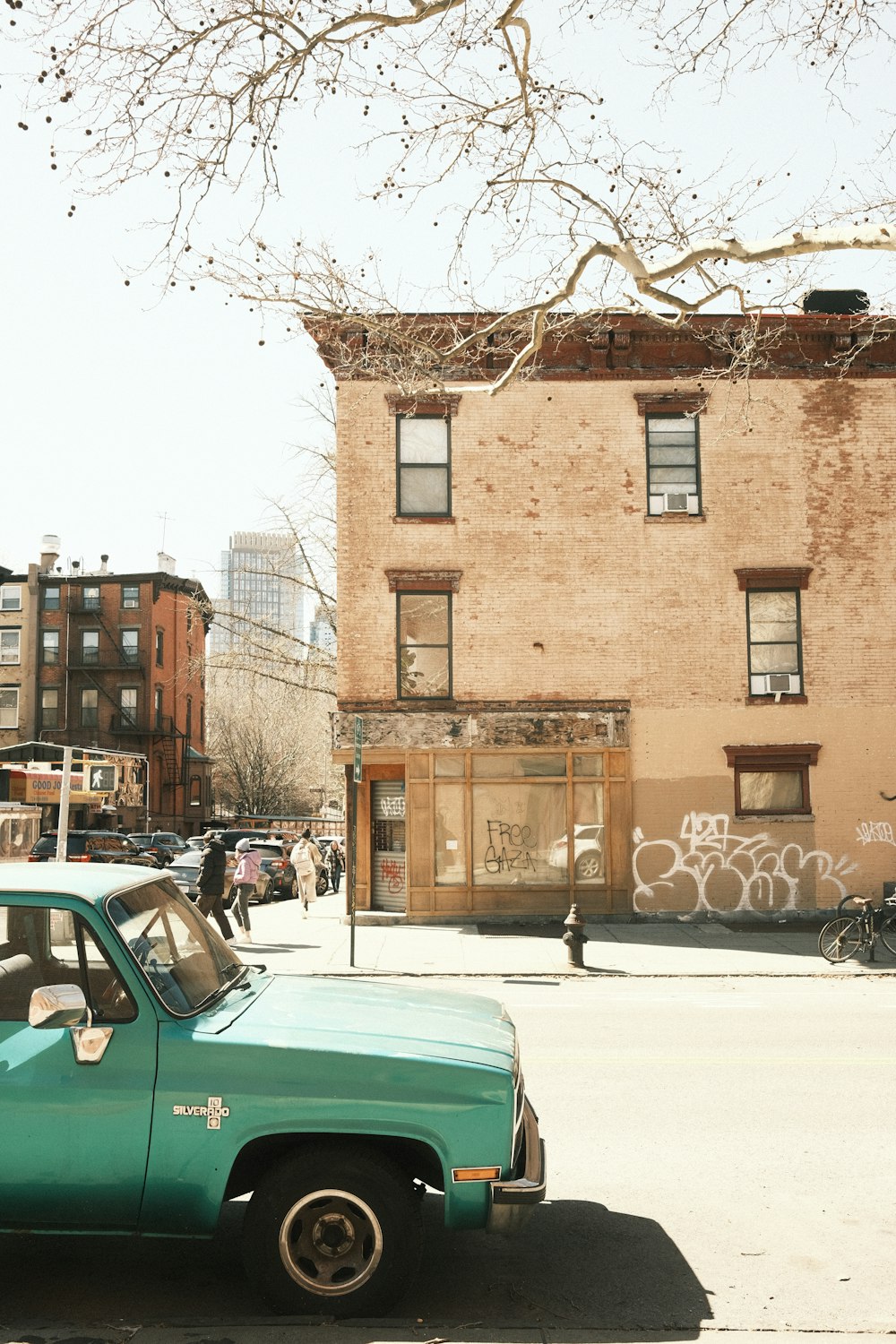 a green truck parked in front of a building