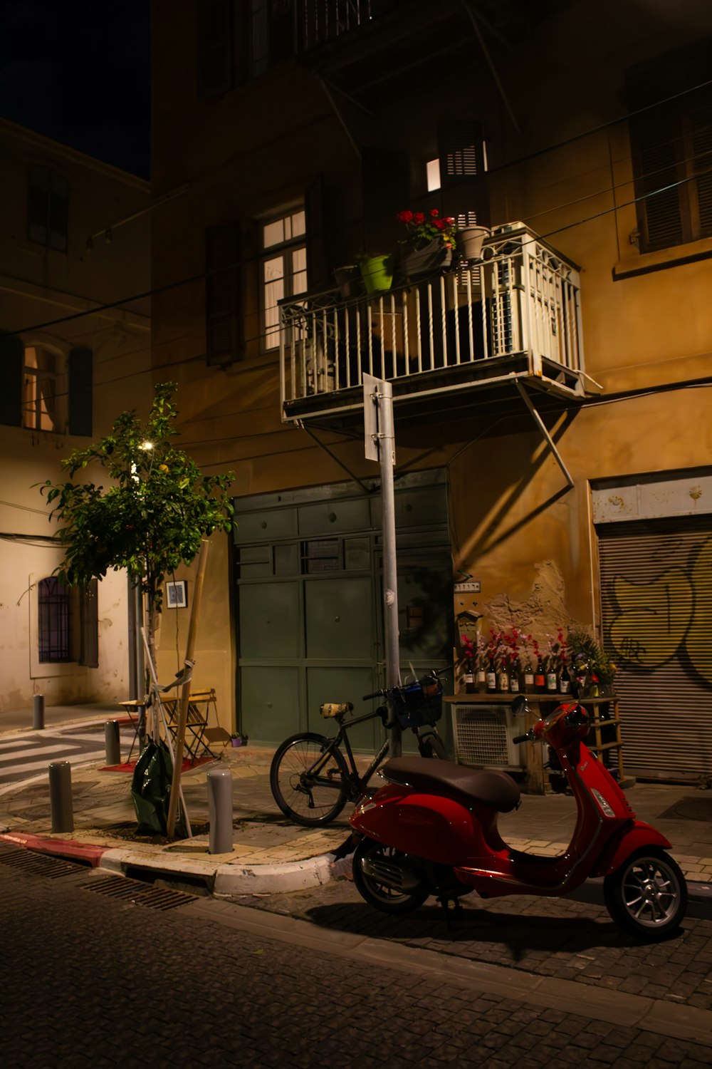 a red scooter parked on the side of a street