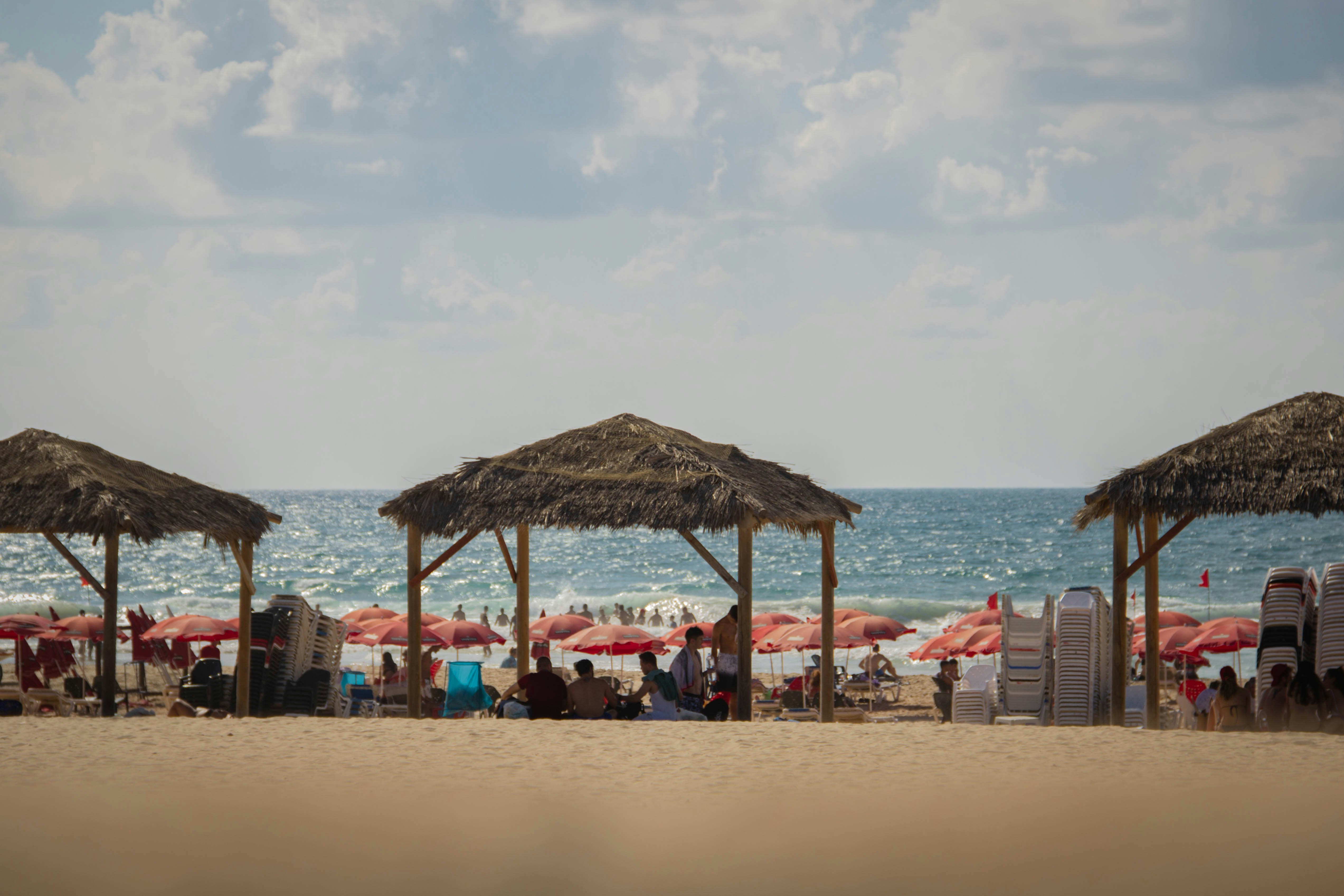 a group of people sitting under umbrellas on a beach