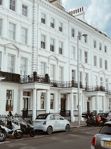 a large white building with many cars parked in front of it