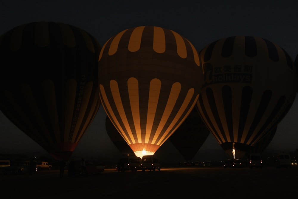 a group of hot air balloons lit up at night