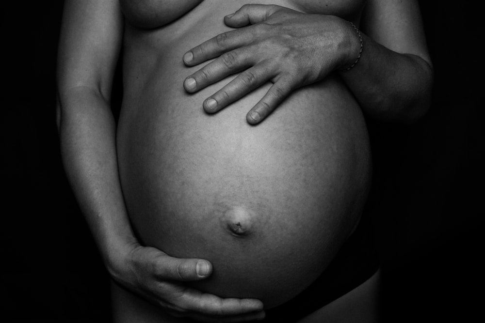 a black and white photo of a pregnant woman