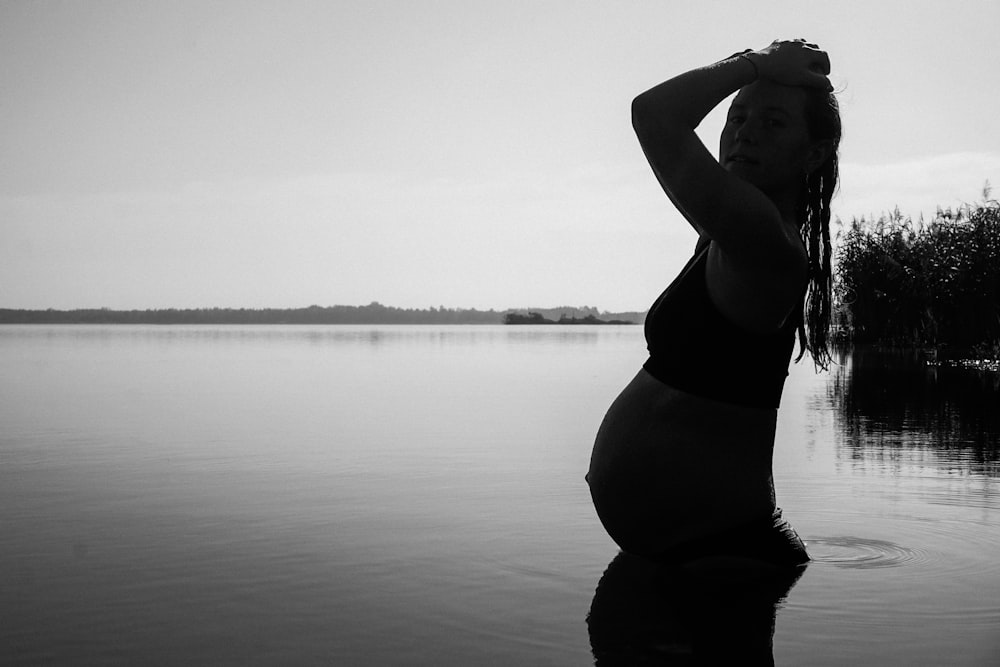 a pregnant woman is standing in the water