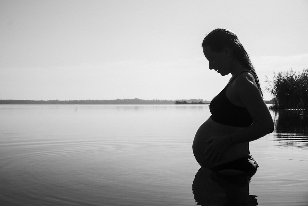 a pregnant woman is standing in the water