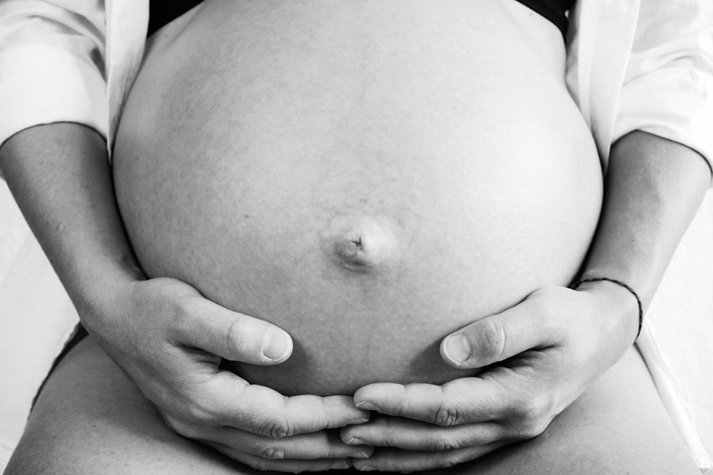 a pregnant woman holding her belly in her hands