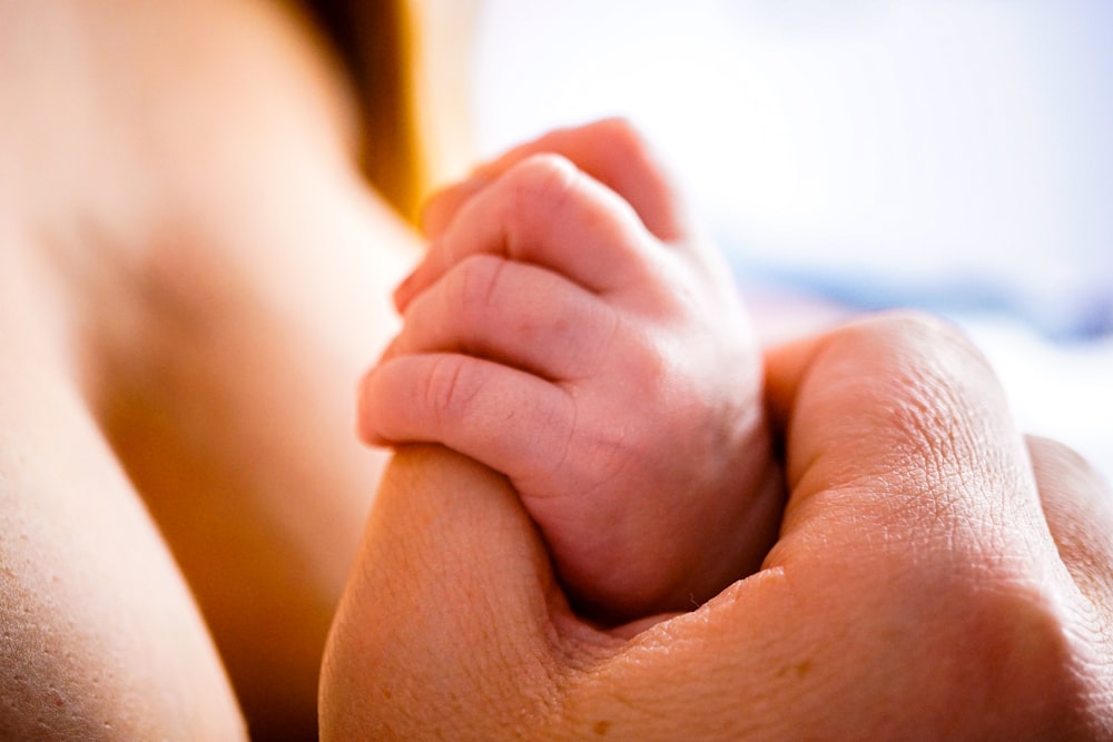 a close up of a person's hand on a bed