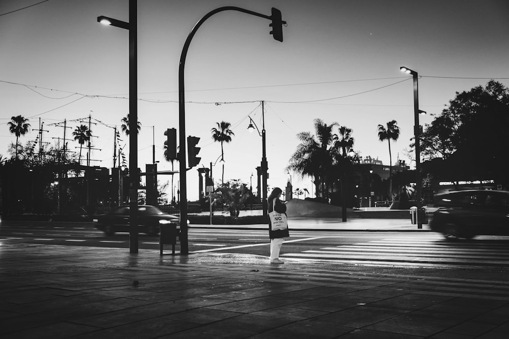 a black and white photo of a person crossing the street