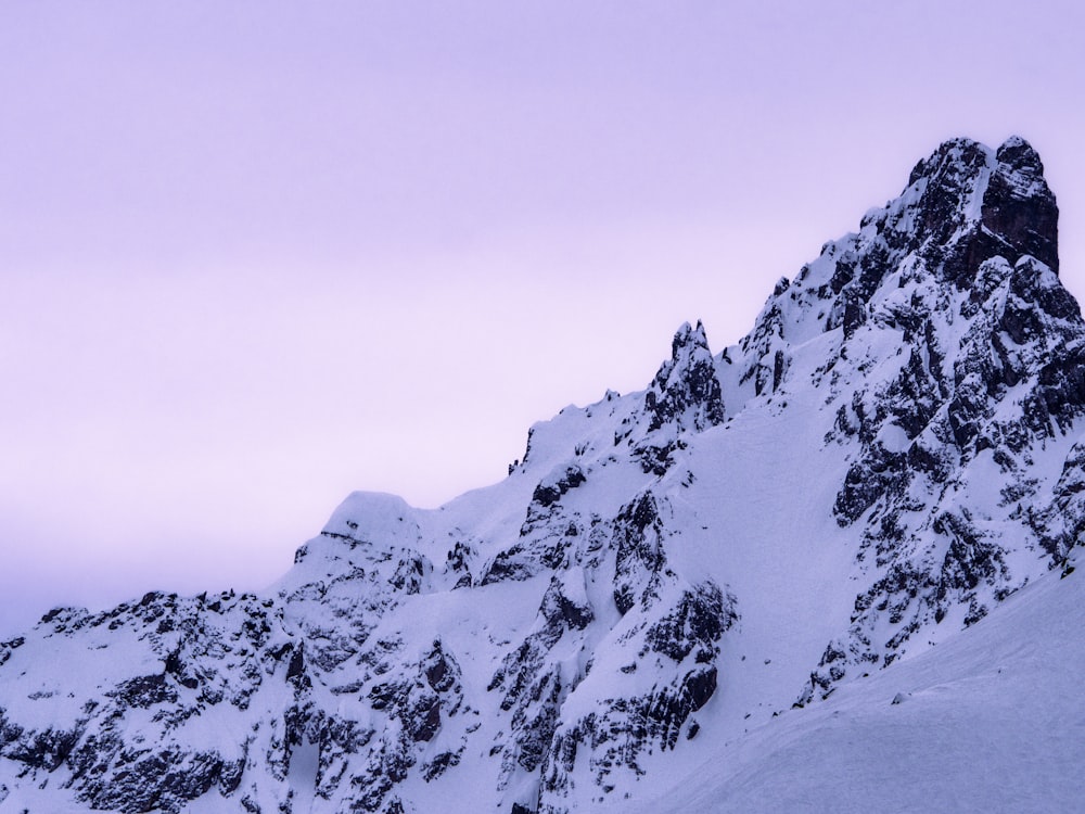 a mountain covered in snow with a sky background