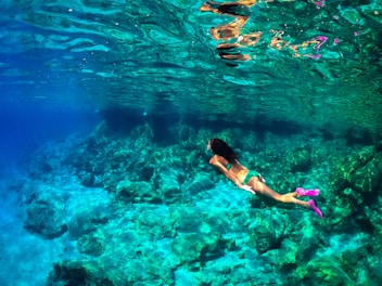a woman in a bikini swimming in the ocean
