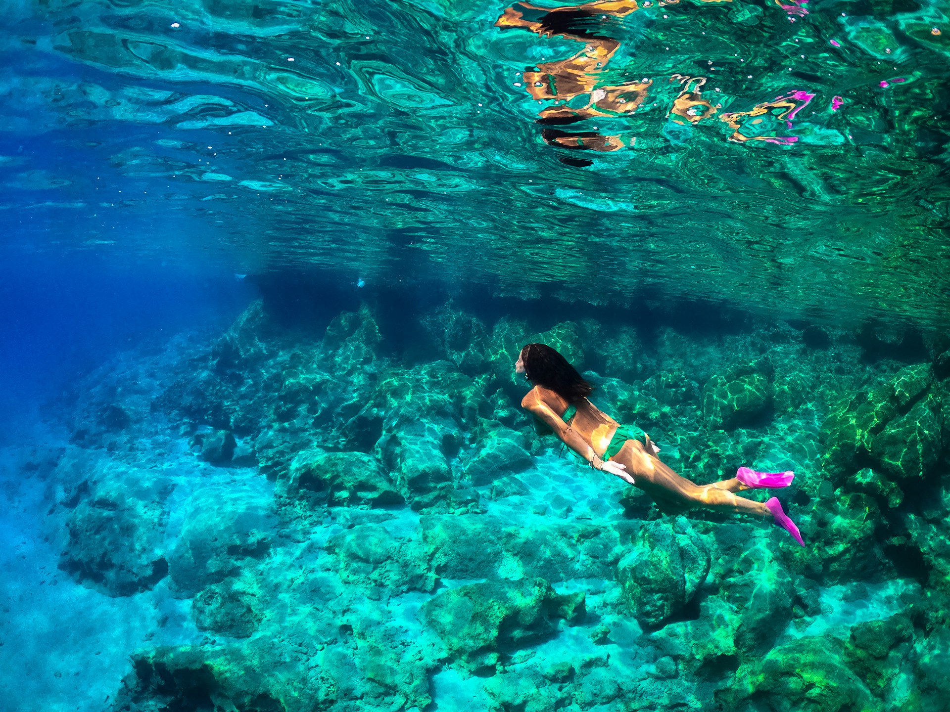 a woman in a bikini swimming in the ocean