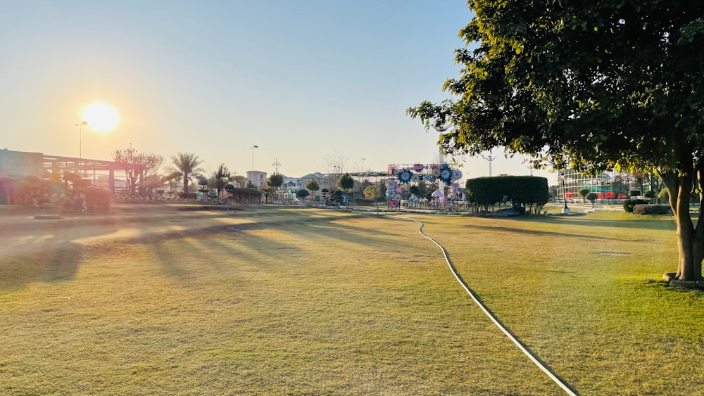 the sun is shining over a park with trees