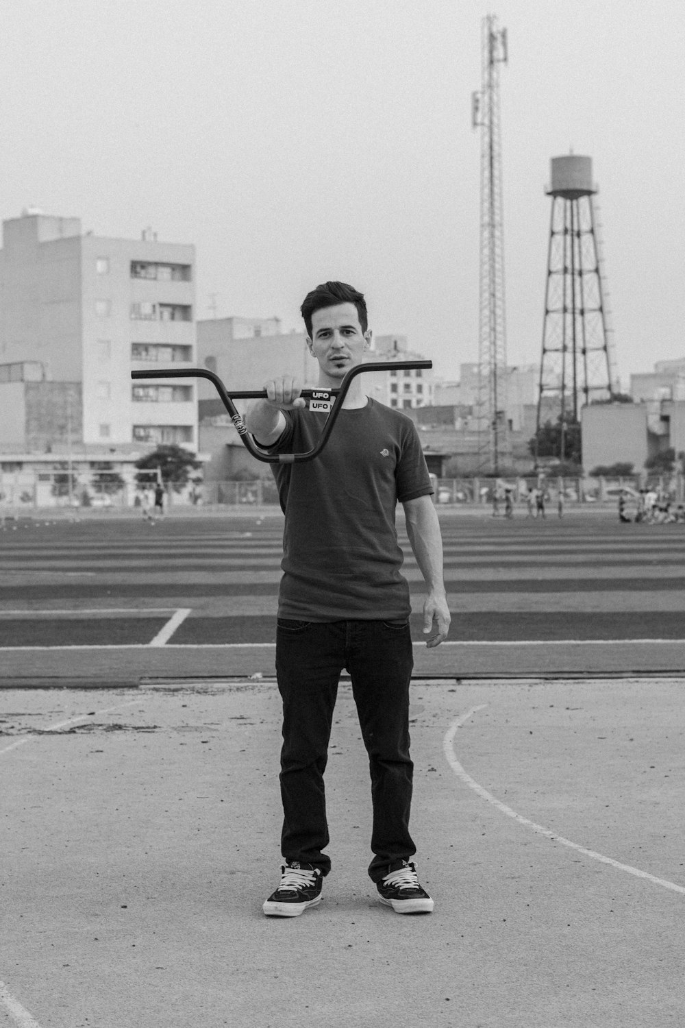 a man holding a baseball bat in a parking lot