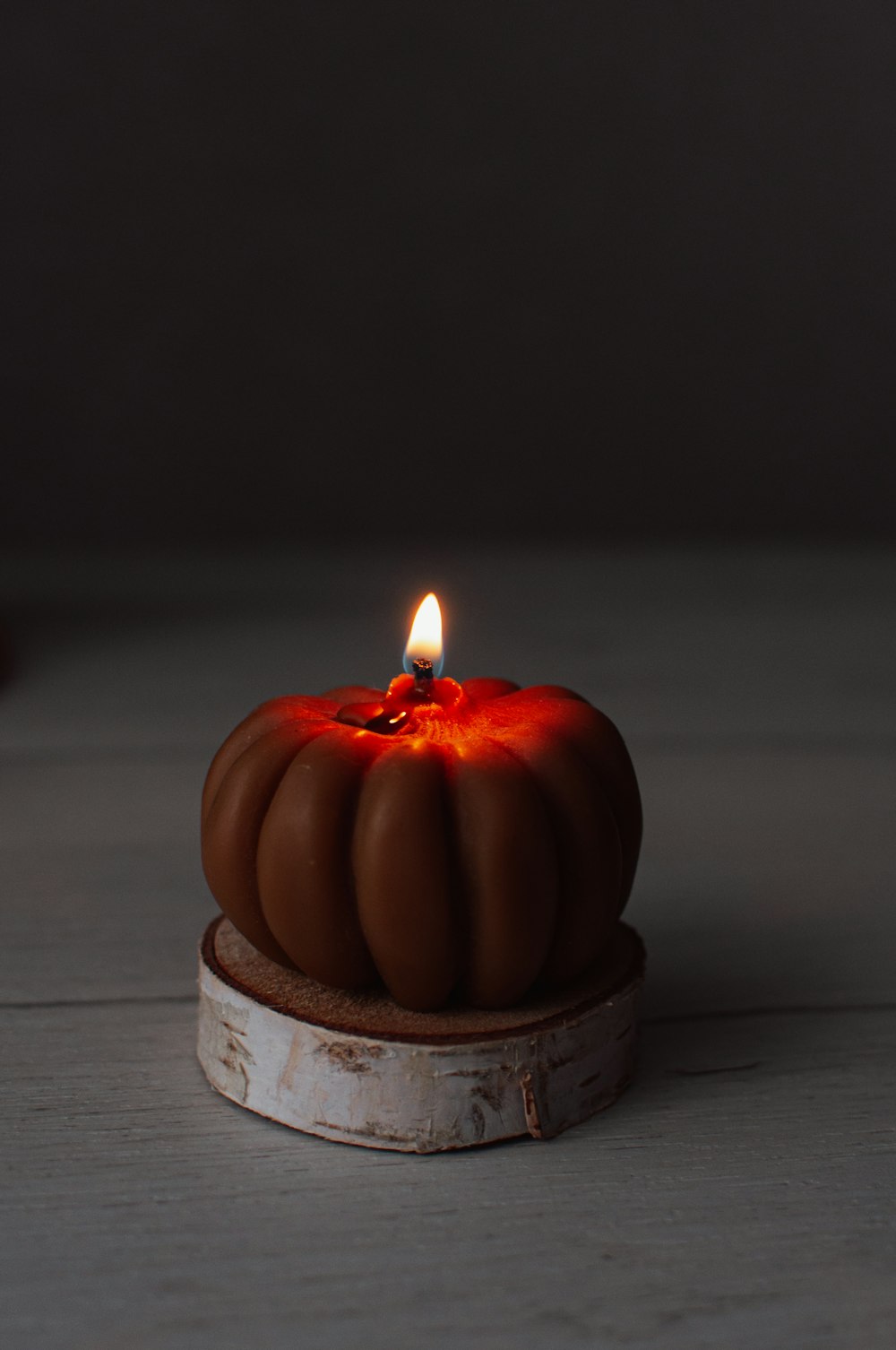 a lit candle sitting on top of a white table