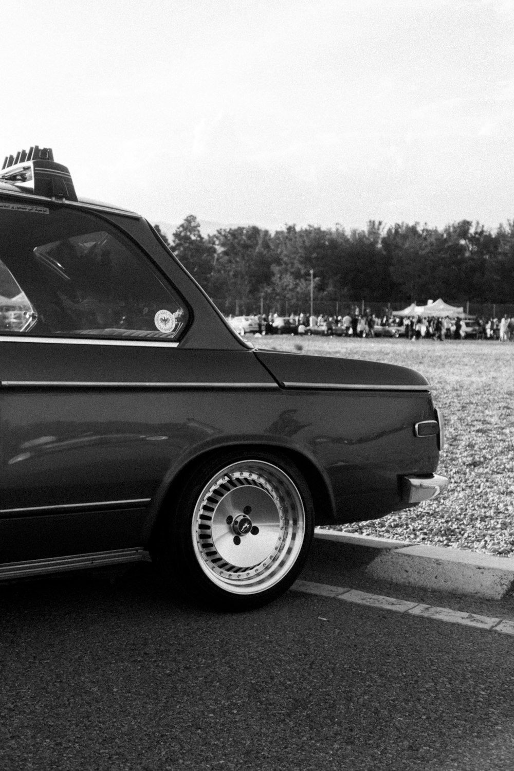 a black and white photo of a car parked in a parking lot