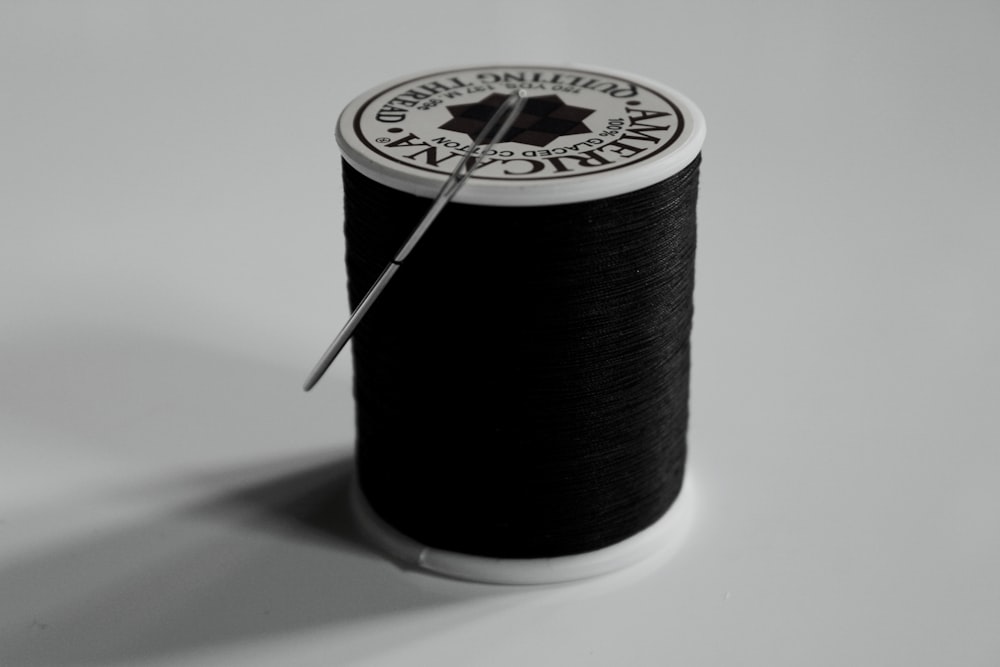 a spool of thread with a needle in it