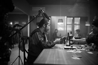 a man sitting at a table with a bottle of wine