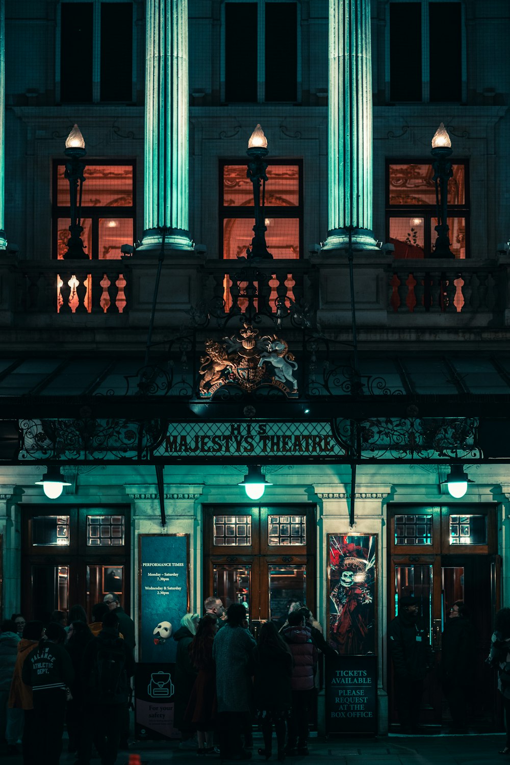 a group of people standing outside of a building at night