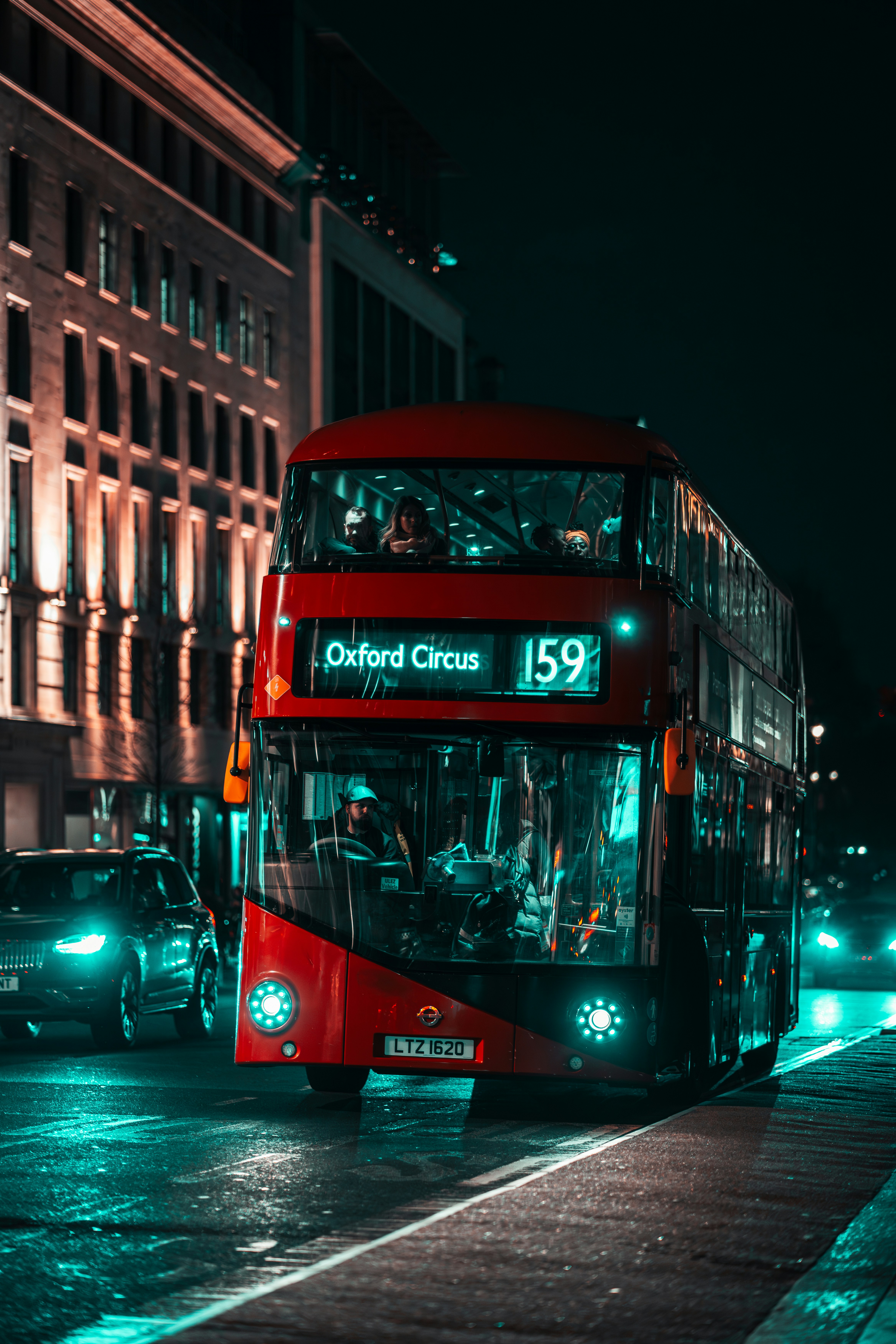 a red double decker bus driving down a street