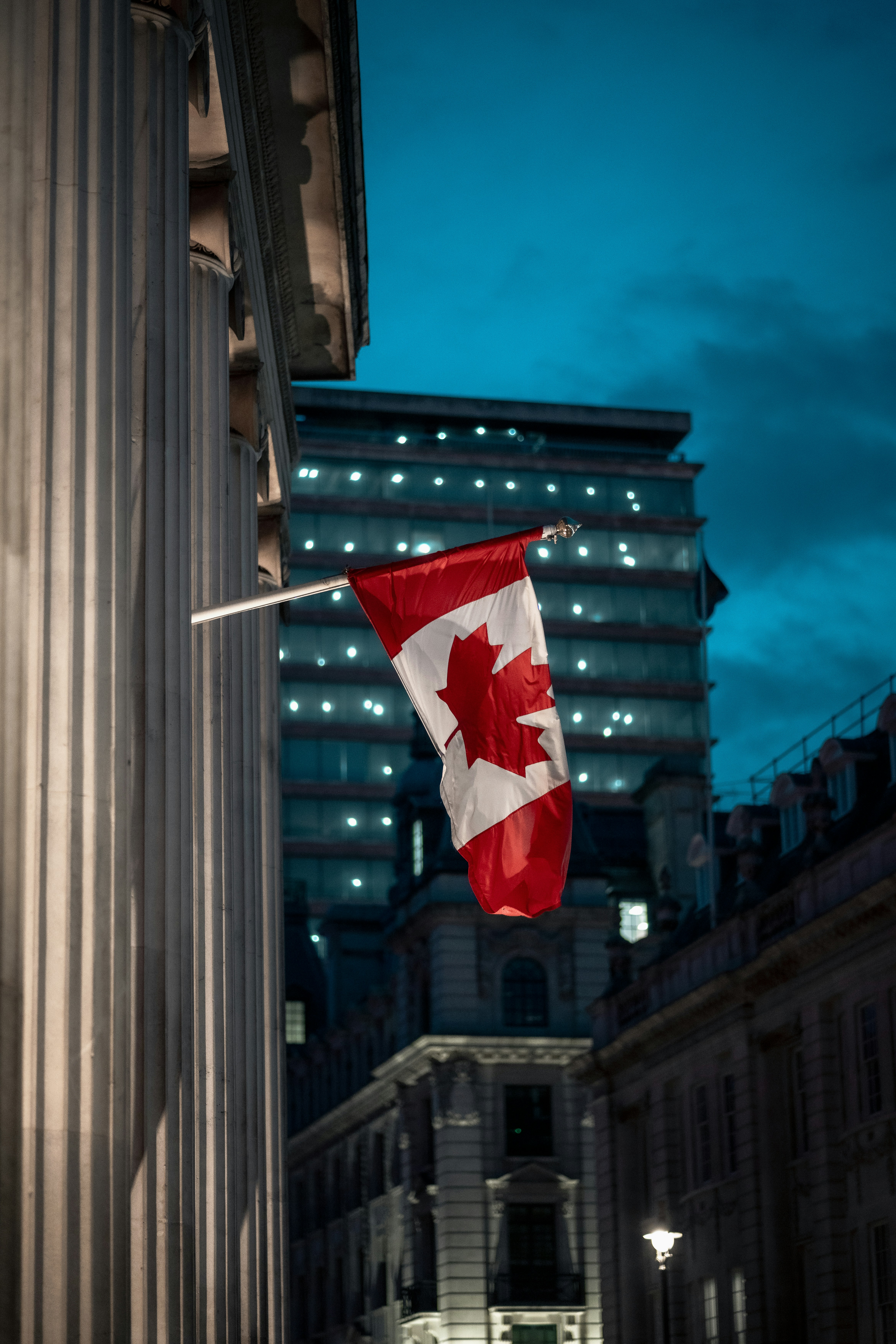 a canadian flag hanging from the side of a building
