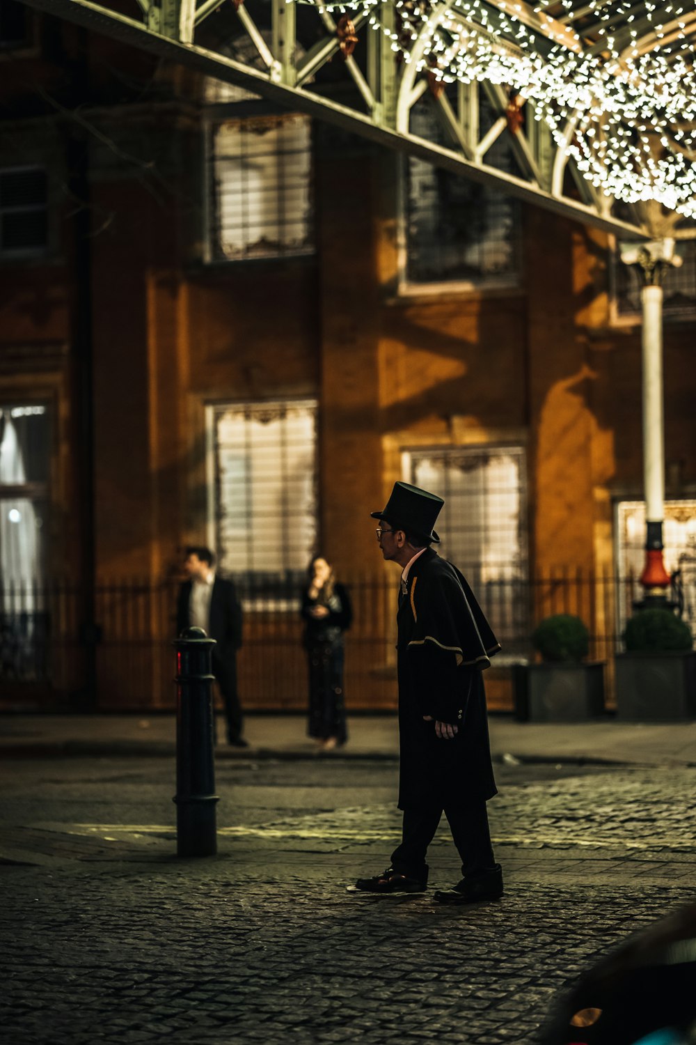 a man in a top hat is walking down the street
