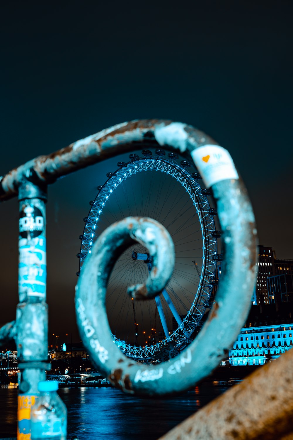 a large ferris wheel sitting next to a body of water