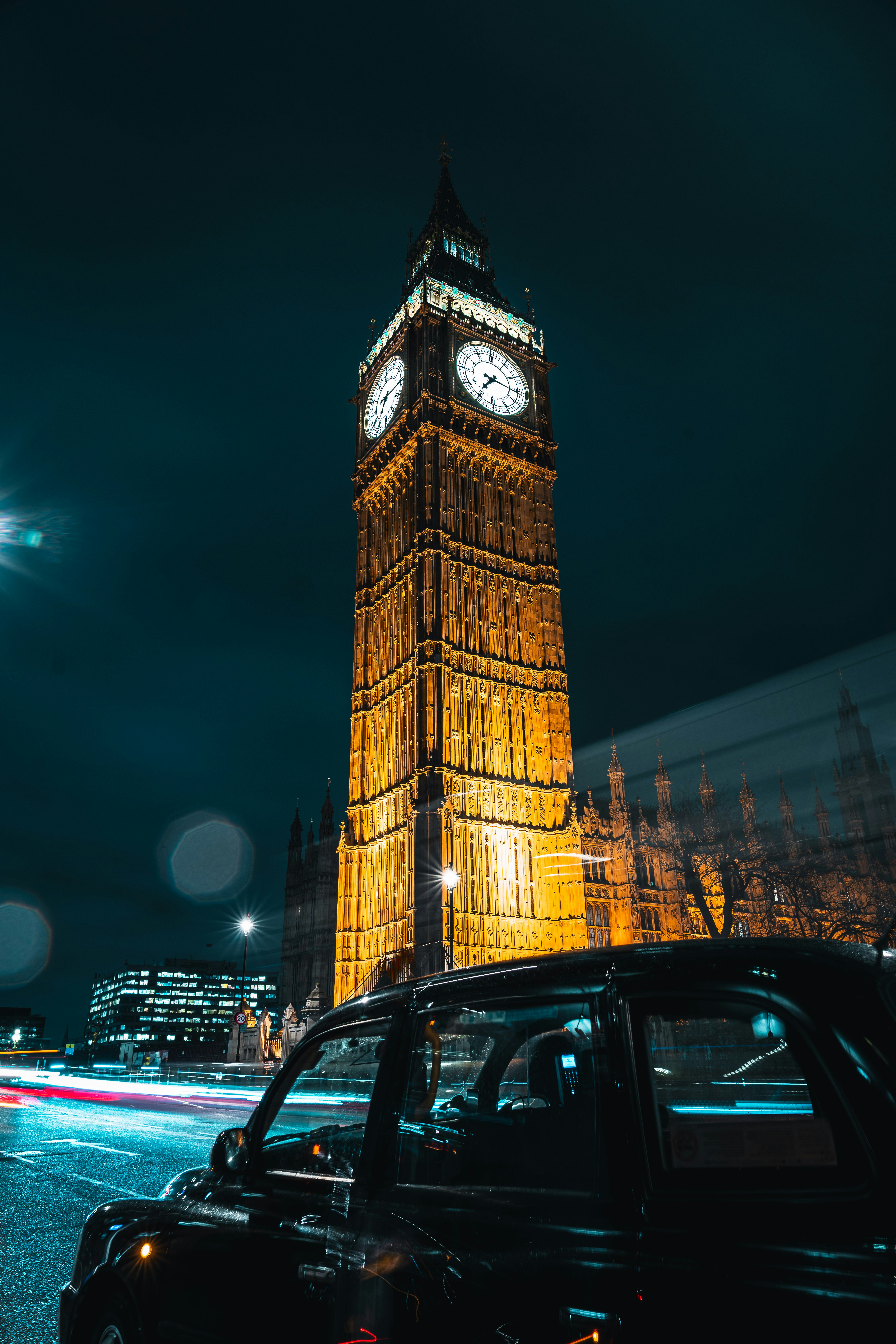 A large clock tower towering over a city at night photo – Free Full hd ...