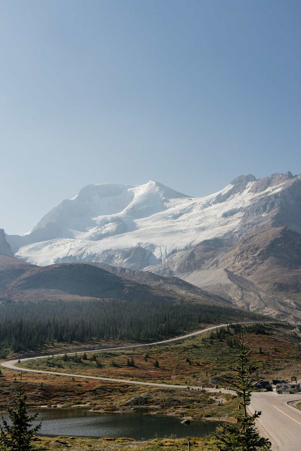 a scenic view of a mountain range with a lake in the foreground