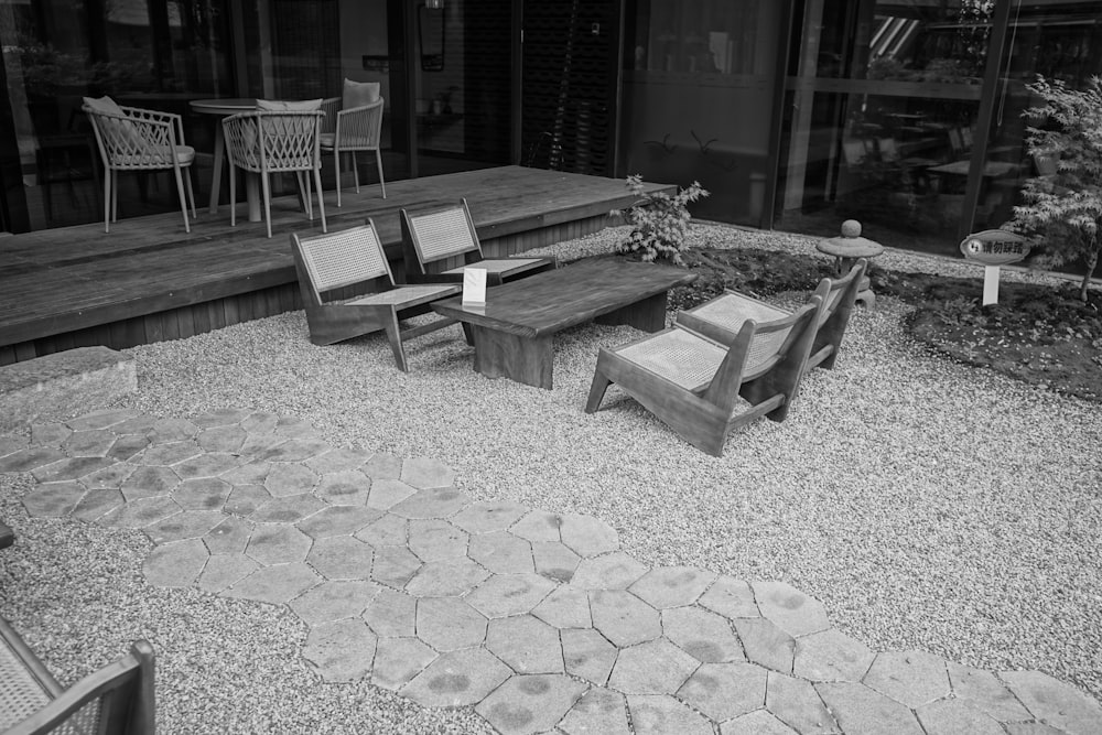 Una foto en blanco y negro de un banco y sillas