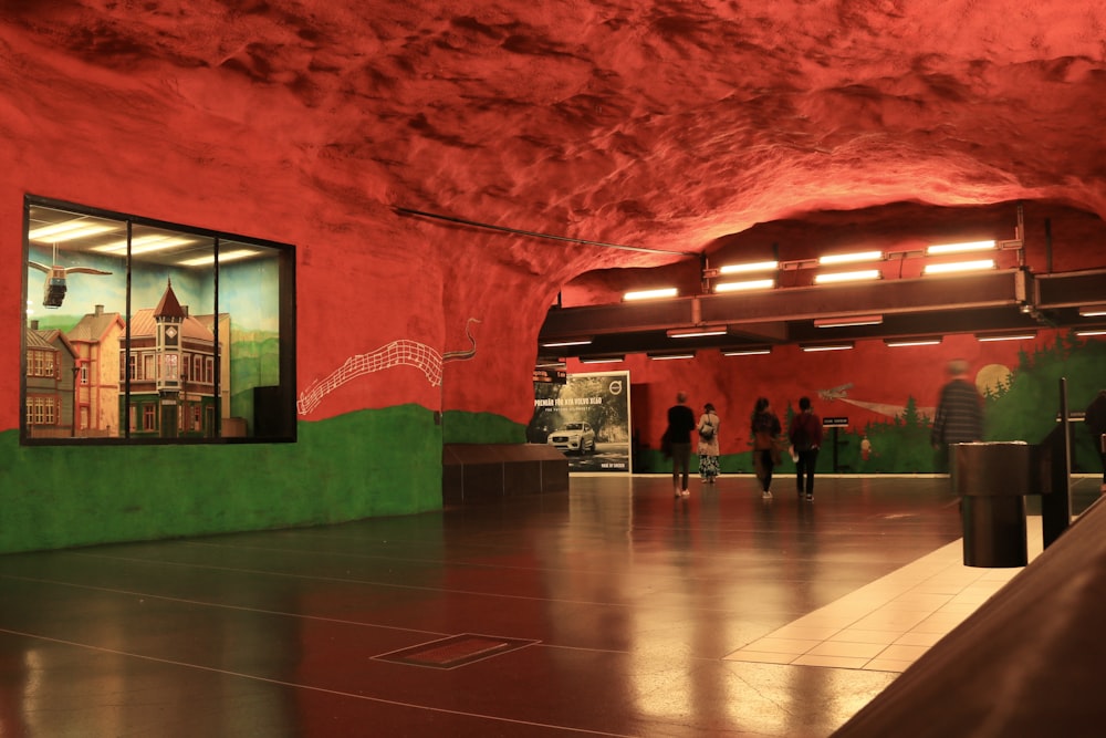 a group of people walking through a red and green tunnel