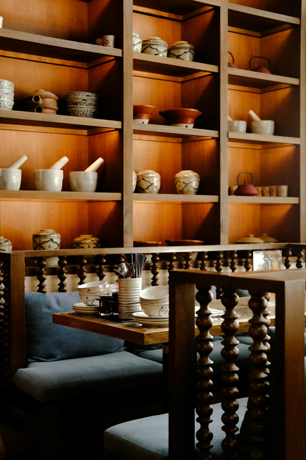 a room with wooden shelves filled with dishes and cups