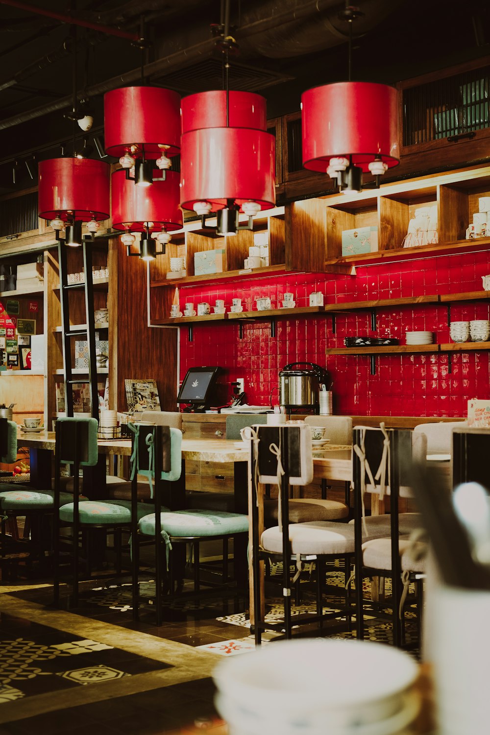 a restaurant with red lamps hanging from the ceiling