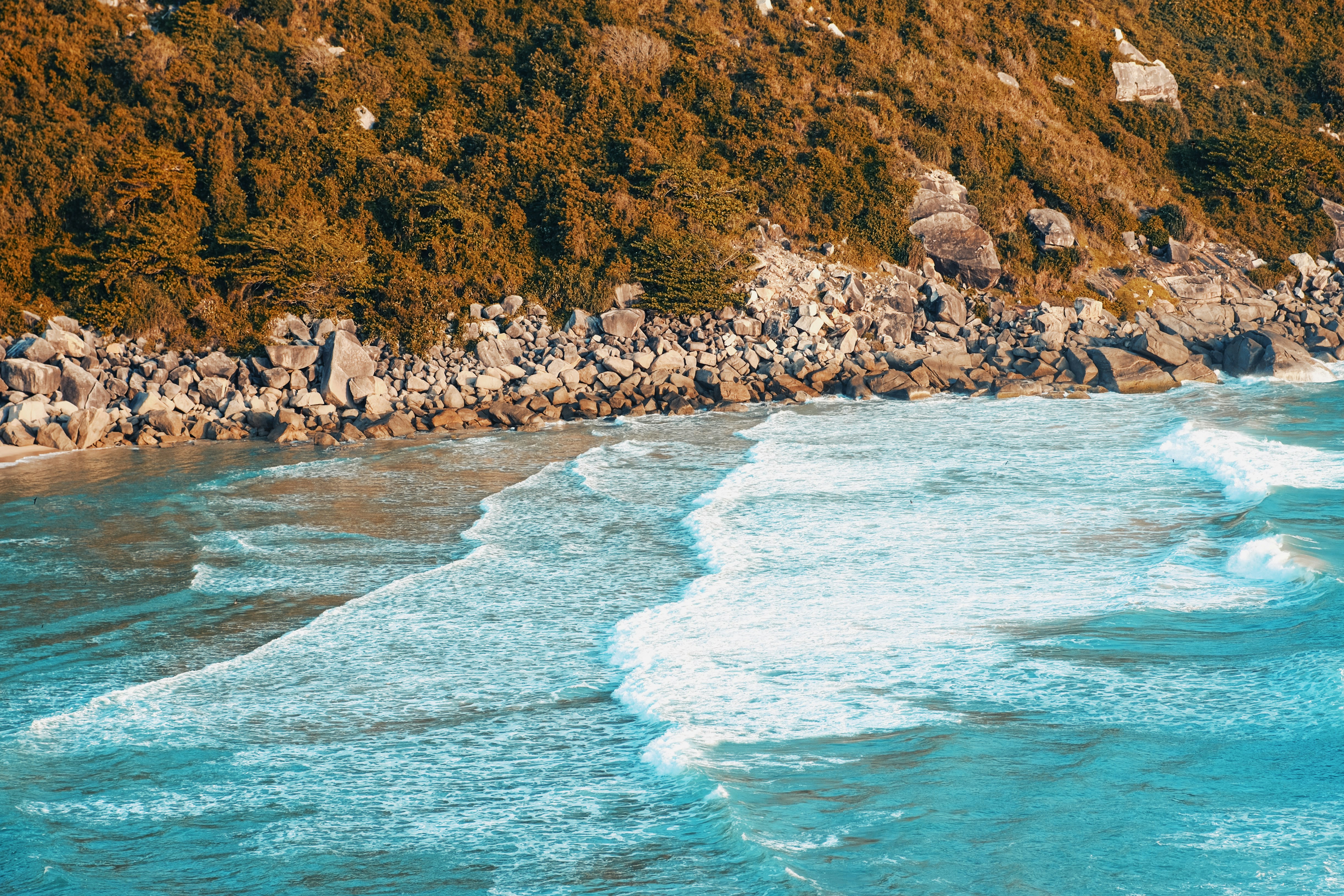 a view of a rocky beach with waves coming in
