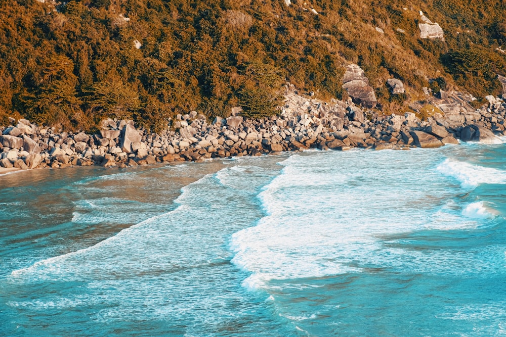 a view of a rocky beach with waves coming in