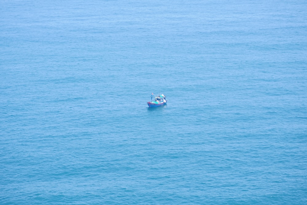 a small boat floating on top of a large body of water