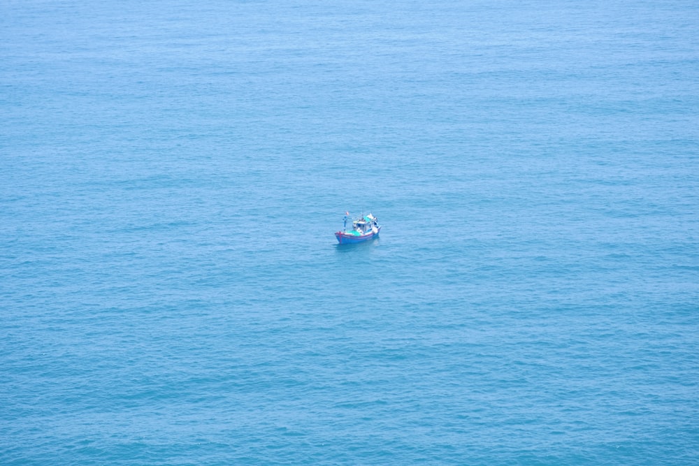 um pequeno barco flutuando em cima de um grande corpo de água