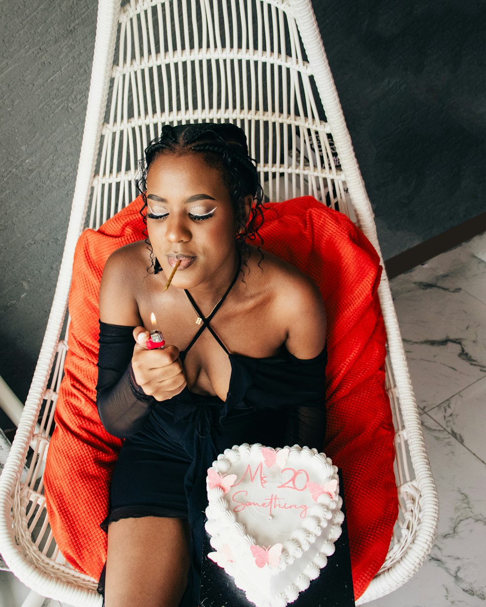 a woman sitting in a chair with a heart shaped cake