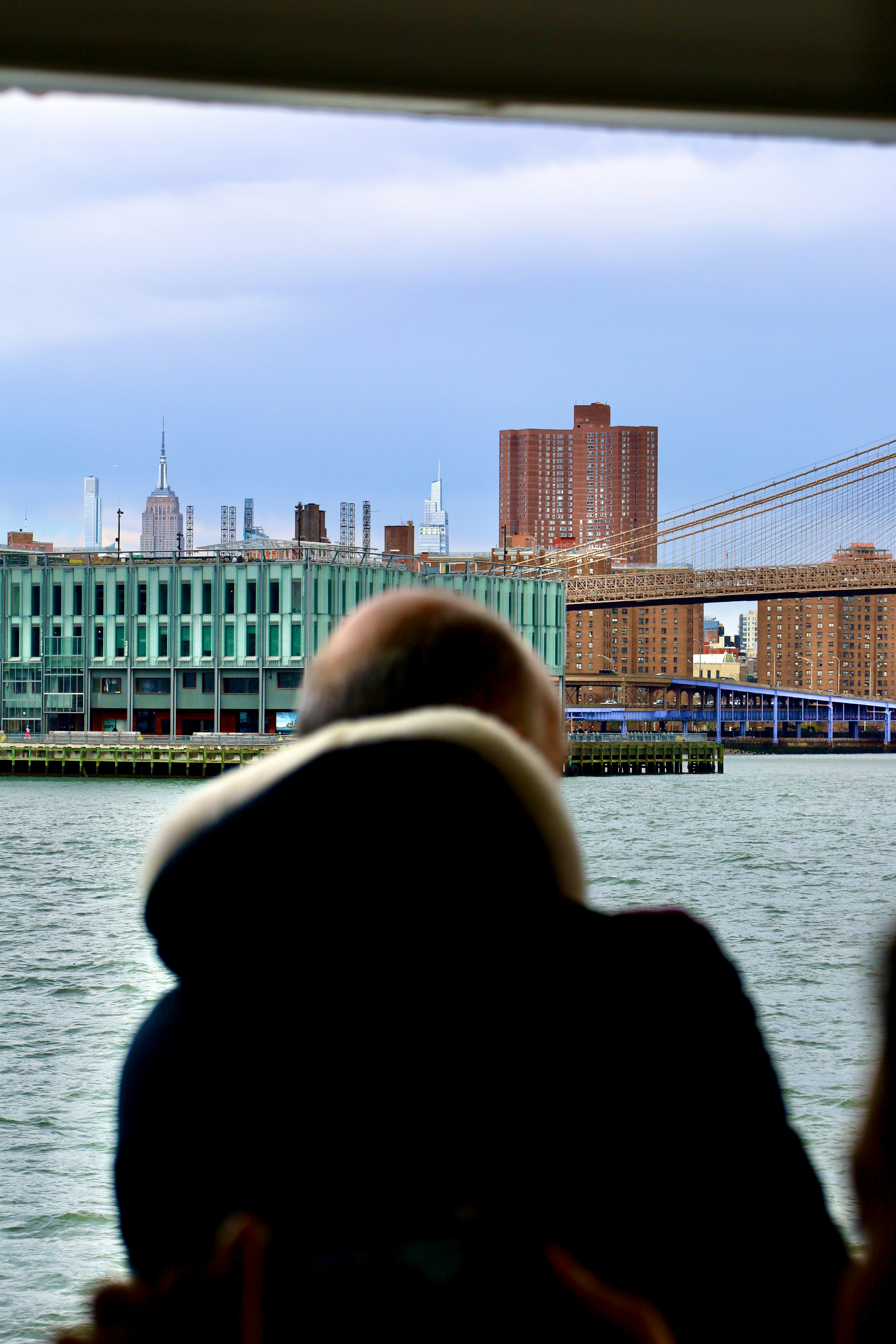 a man looking out a window at a bridge