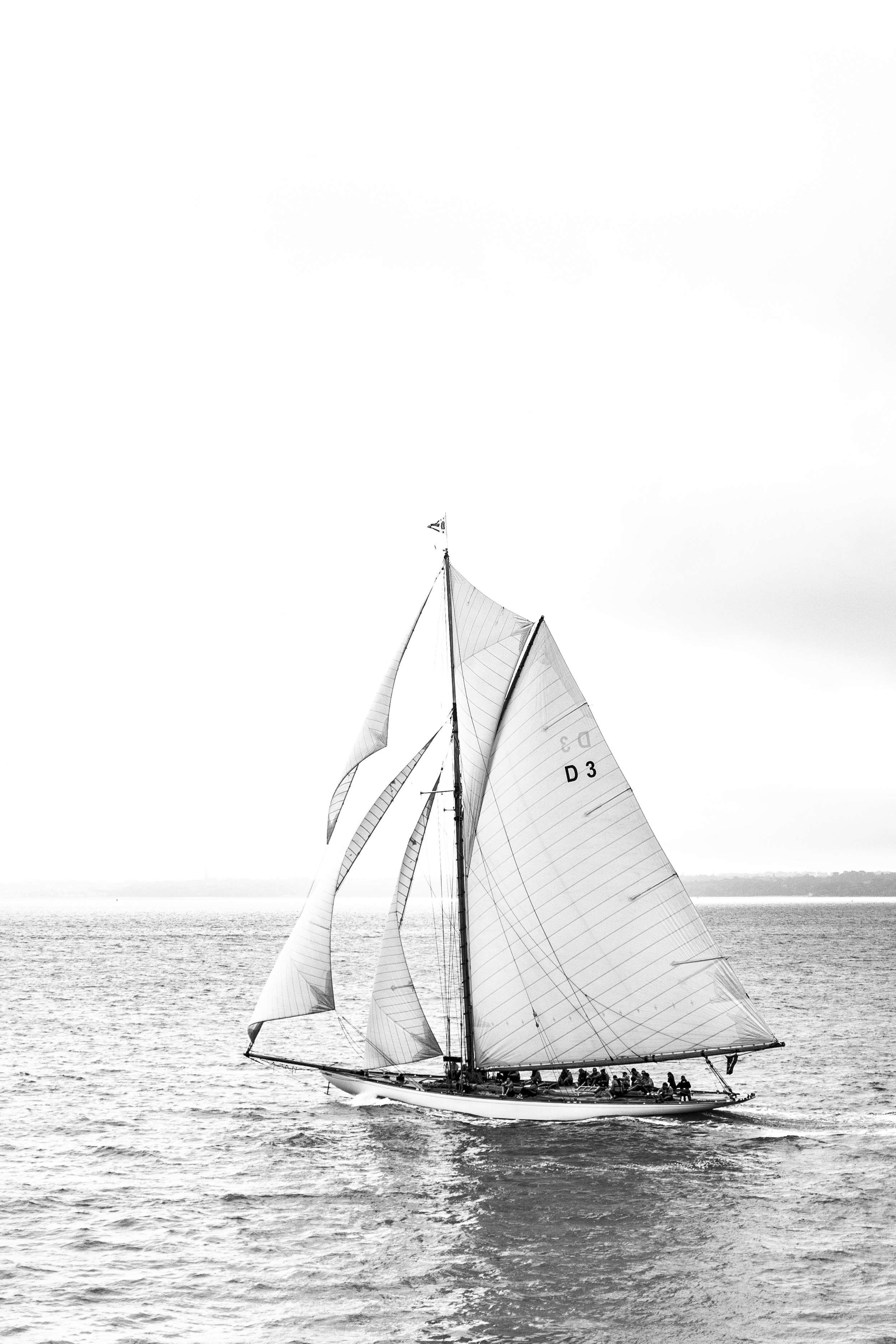 a black and white photo of a sailboat in the ocean