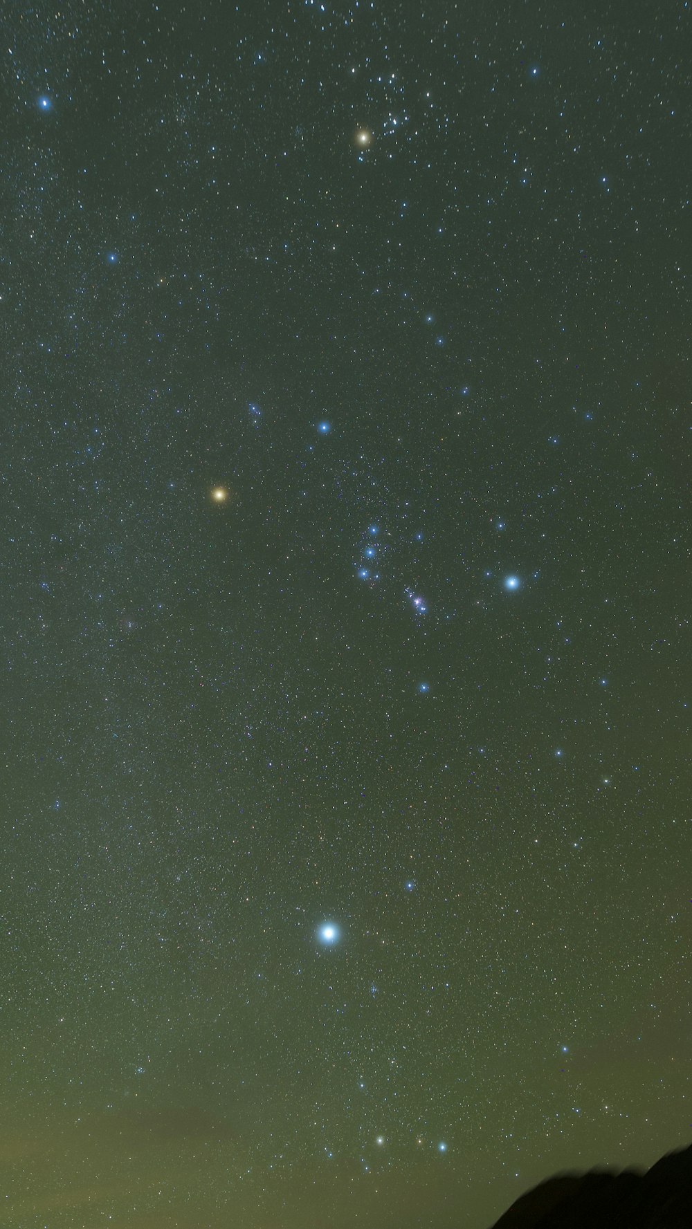 the night sky with stars and a mountain in the background