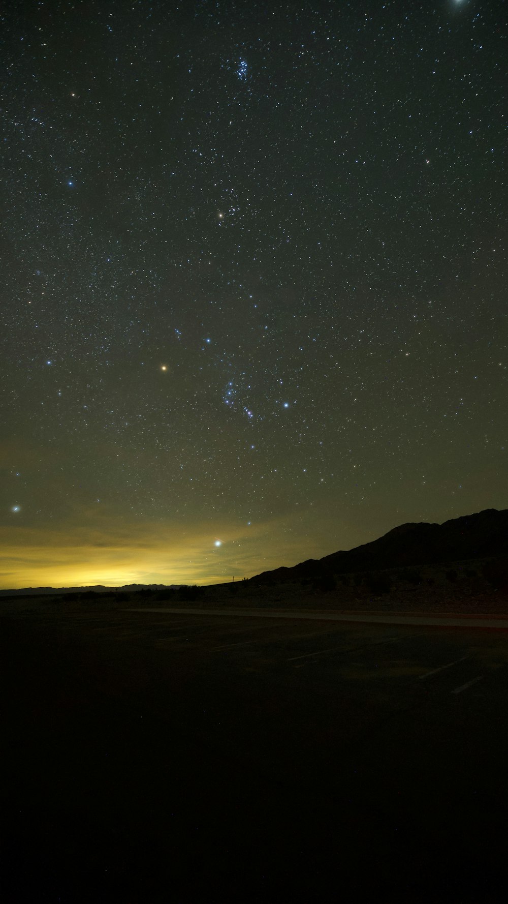 the night sky with stars and a mountain in the background